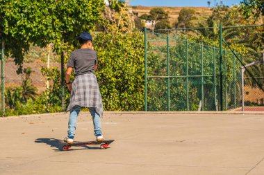 Kaykay parkında kaykay yapan bir çocuk.