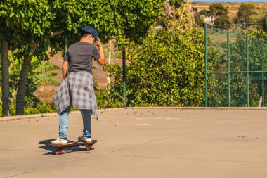 Kaykay parkında kaykay yapan bir çocuk.