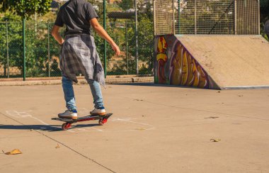 Kaykay parkında kaykay yapan tanınmamış bir çocuk.