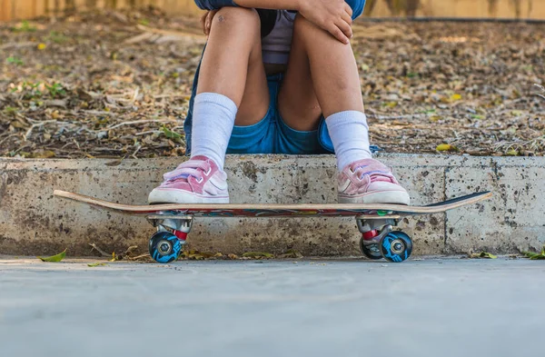 スケートパークに座っている女の子のスケートボードの足 — ストック写真