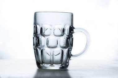 Beyaz arka planda şeffaf cam bira bardağı