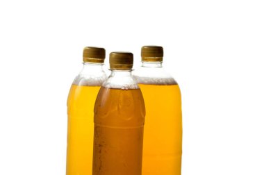 Beyaz arka planda şeffaf plastik şişelerde köpüklü bira.