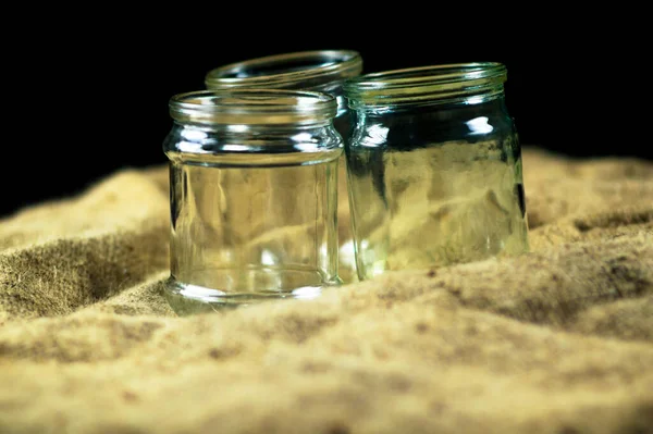 Glass jars on a black background for storing food for the winter — Stock Image Glass Jars Black Background Storing Food Winter Stock Photo