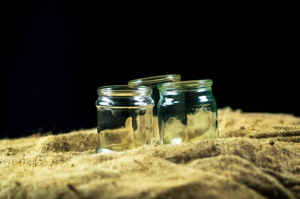 Glass jars on a black background for storing food for the winter — Stock Image Glass Jars Black Background Storing Food Winter Stock Photo