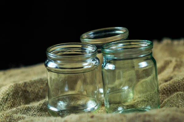 Glass jars on a black background for storing food for the winter — Stock Image Glass Jars Black Background Storing Food Winter Stock Image