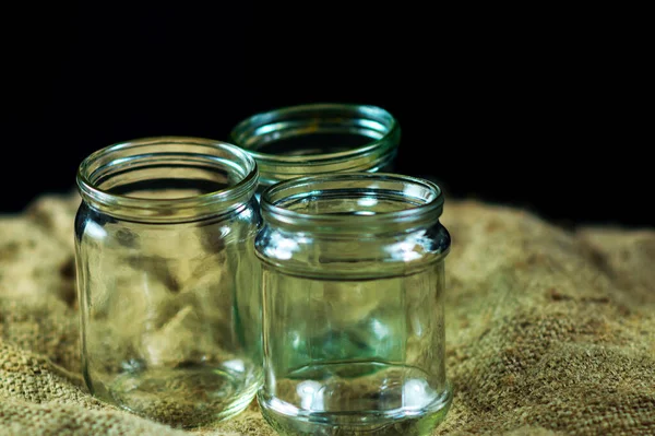 Glass jars on a black background for storing food for the winter — Stock Image Glass Jars Black Background Storing Food Winter Stock Image