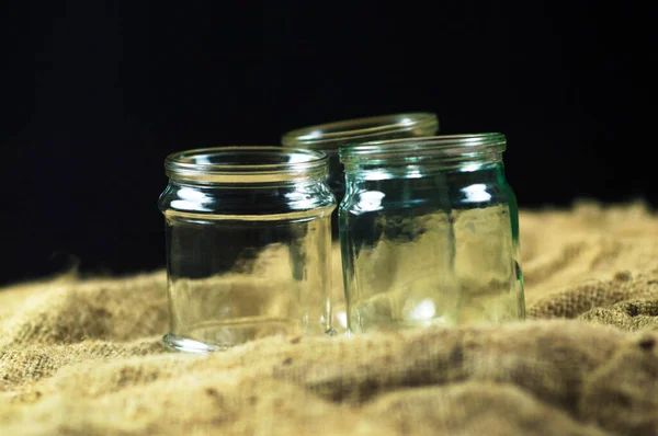 Glass jars on a black background for storing food for the winter — Stock Image Glass Jars Black Background Storing Food Winter Stock Photo