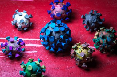 Kırmızı zemin üzerinde plasticine coronavirus 'un soyut çok renkli figürleri