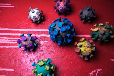 Kırmızı zemin üzerinde plasticine coronavirus 'un soyut çok renkli figürleri