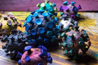 Çok renkli arkaplanda plasticine koronavirüsten soyut çok renkli figürler