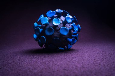 Mor arkaplandaki plasticine coronavirus 'tan soyut bir figür