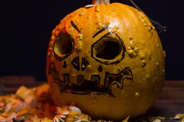 art scary Halloween with pumpkins and an old kerosene lamp in a red light preparation for the celebration in a dark room