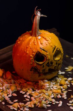 art scary Halloween with pumpkins and an old kerosene lamp in a red light preparation for the celebration in a dark room