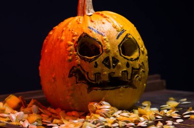 art scary Halloween with pumpkins and an old kerosene lamp in a red light preparation for the celebration in a dark room
