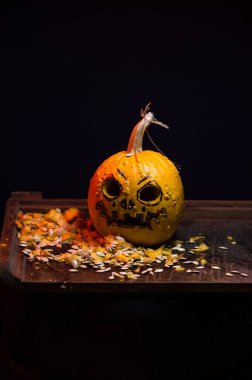 art scary Halloween with pumpkins and an old kerosene lamp in a red light preparation for the celebration in a dark room