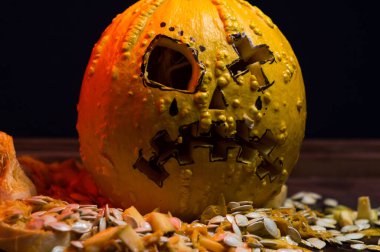 art scary Halloween with pumpkins and an old kerosene lamp in a red light preparation for the celebration in a dark room
