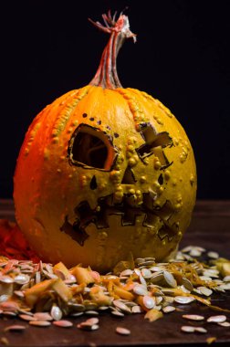 art scary Halloween with pumpkins and an old kerosene lamp in a red light preparation for the celebration in a dark room