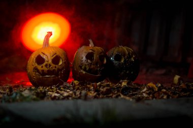 autumn holiday Halloween 2025 scary orange pumpkins burning in fire and smoke with blood red light in the dark