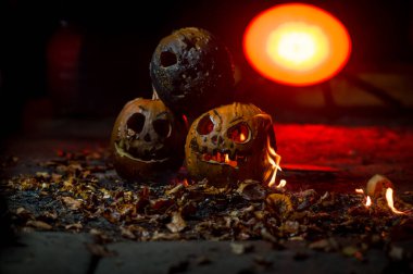 autumn holiday Halloween 2025 scary orange pumpkins burning in fire and smoke with blood red light in the dark