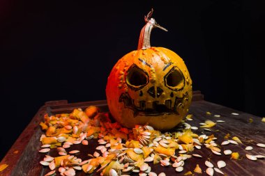art scary Halloween with pumpkins and an old kerosene lamp in a red light preparation for the celebration in a dark room