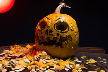 art scary Halloween with pumpkins and an old kerosene lamp in a red light preparation for the celebration in a dark room