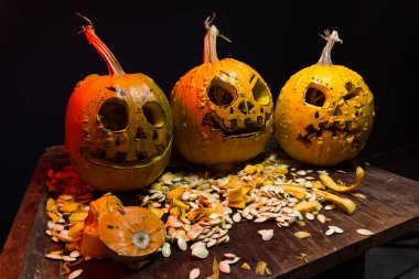 art scary Halloween with pumpkins and an old kerosene lamp in a red light preparation for the celebration in a dark room