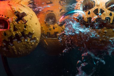 autumn holiday Halloween 2025 scary orange pumpkins drowning in water with bubbles and splatters in blood red light in the dark