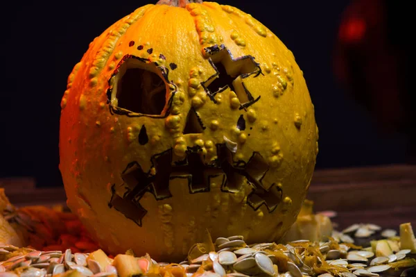art scary Halloween with pumpkins and an old kerosene lamp in a red light preparation for the celebration in a dark room