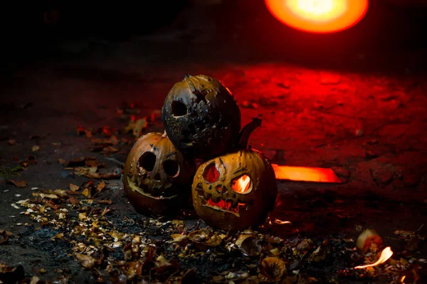 autumn holiday Halloween 2025 scary orange pumpkins burning in fire and smoke with blood red light in the dark