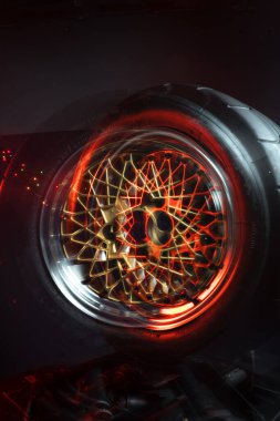 Eski moda tekerler katlanabilir. Altın merkezli ve parlak jantlı. Hareketi taklit etmek için uzun pozlama fotoğrafı.