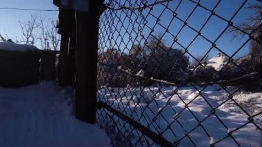 Kışın güneşli bir havada, karlı bir bahçede kar temizliği.