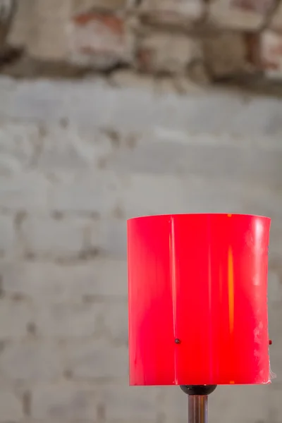 Close-up met rode lamp. Rode verticale lamp met oude muren achter. — Stockfoto