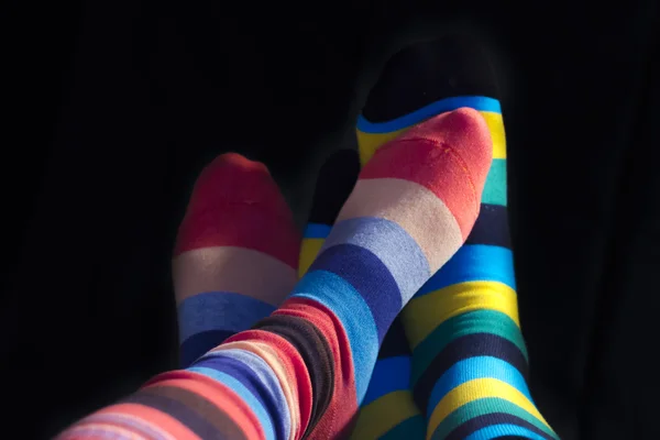 Colored socks on teenagers feet isolated on black — Stock Photo, Image