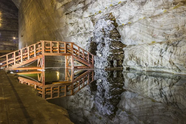 Reflejo de puente de madera en lago subterráneo de mina de sal — Foto de Stock