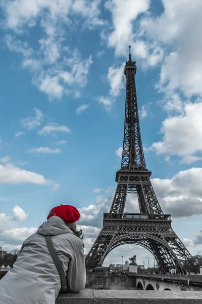 Jovem turista com chapéu vermelho de estilo parisiense olhando para a torre Eiffel do lado do rio Sena — Fotografia de Stock