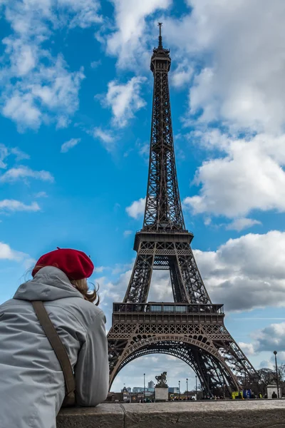 Jovem turista com chapéu vermelho de estilo parisiense olhando para a torre Eiffel do lado do rio Sena — Fotografia de Stock