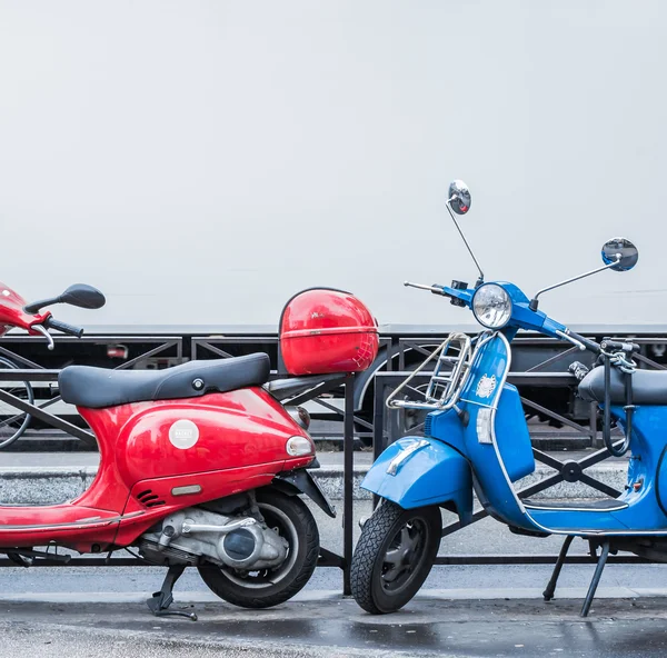 Scooters azules y rojos sobre borrosa pista blanca símbolo de azul, blanco y rojo bandera de Francia — Foto de Stock