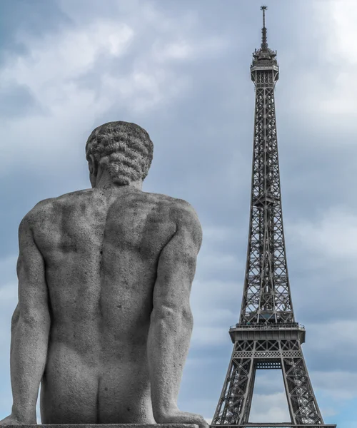 Stone statue over Eiffel tower on background — Stockfoto