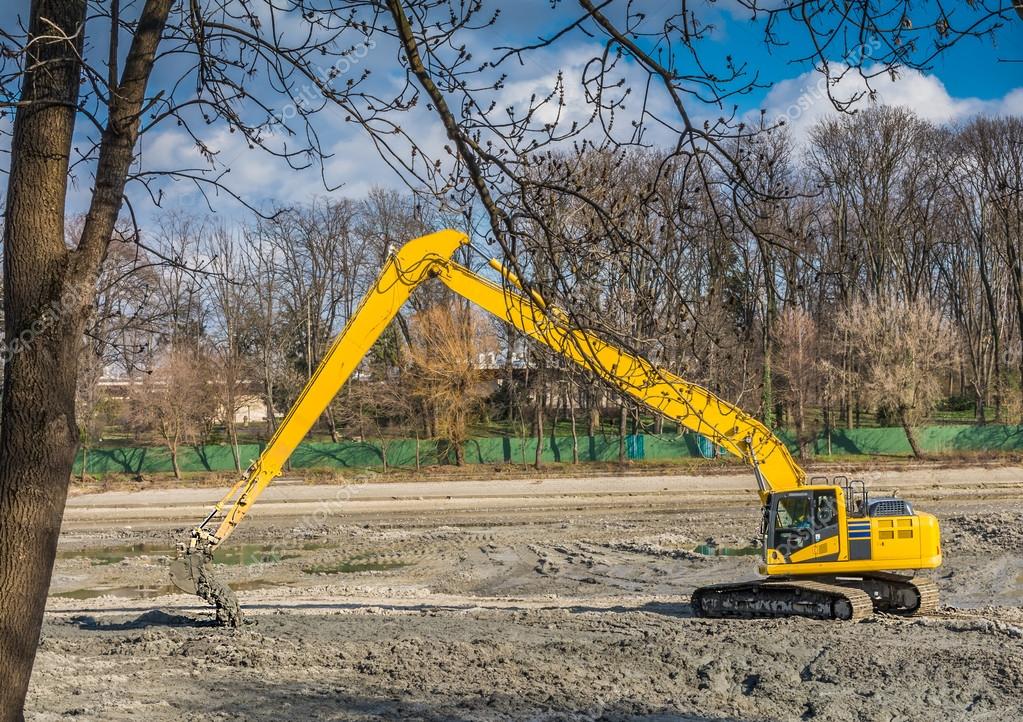 Yellow excavator doing lake cleaning and maintenance services under municipality authority  in a park
