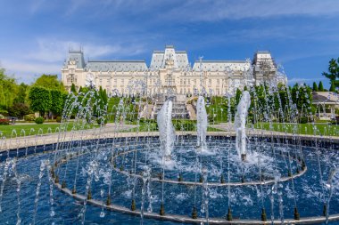 Iasi, Romanya - 23 Mayıs 2015: Iasi Kültür Sarayı ile arka plan üzerinde dramatik gökyüzü güneşli bahar gününde restaurated ile güzel bir yeşil park ediliyor