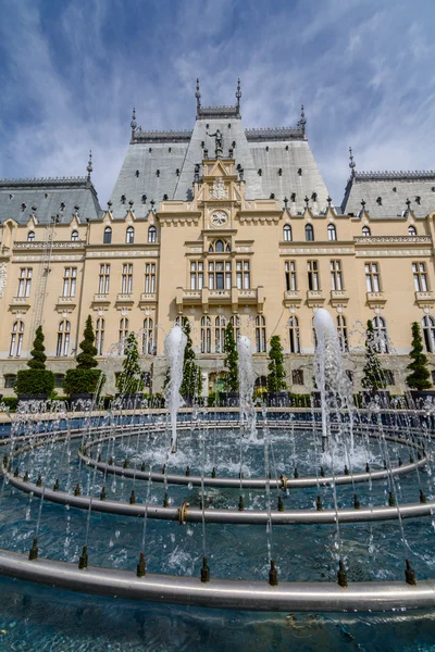 IASI, RUMANIA - 23 DE MAYO DE 2015: El Palacio Cultural de Iasi está siendo restaurado con un hermoso parque verde en un soleado día de primavera con un cielo dramático en el fondo —  Fotos de Stock