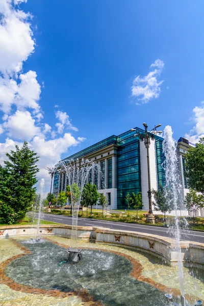 BUCHAREST, ROMANIA - AUGUST 30, 2015: Nationalbiblioteket på Splaiul Unirii på en solrig dag med Dambovita-floden foran - Stock-foto