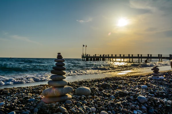 Pebbles de torre com fundo de pôr do sol e uma ponte — Fotografia de Stock