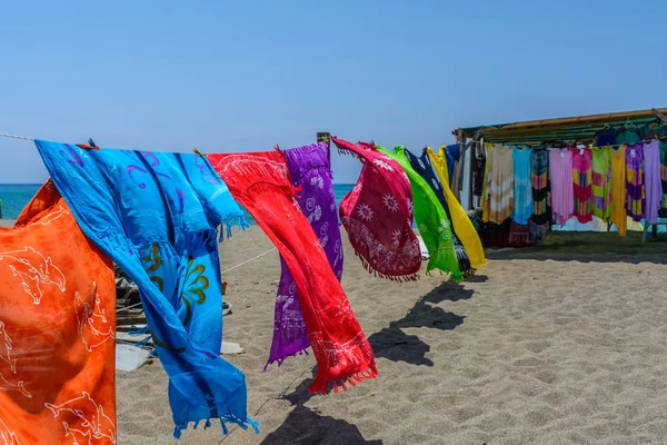 Bufandas coloridas sopladas por el polvo en la playa en un día soleado de verano —  Fotos de Stock