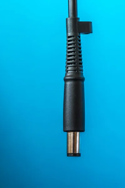 Conector de alimentação de fio de cabeça preta no fundo azul — Fotografia de Stock