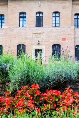 Tuğla bina ve ön plan güzel çiçeklere
