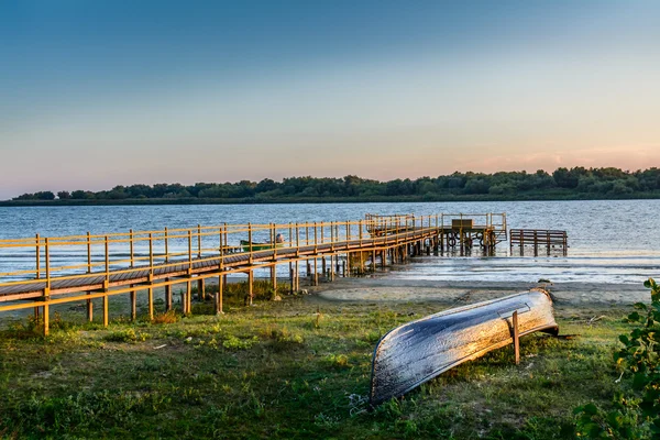 Altes Boot an der Küste in der Nähe der Anlegestelle. rustikale Landschaft mit Holz — Stockfoto