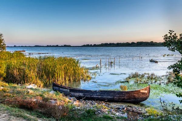 Altes Boot auf dem Wasser im See inmitten des Schilfs. hell und ca. — Stockfoto