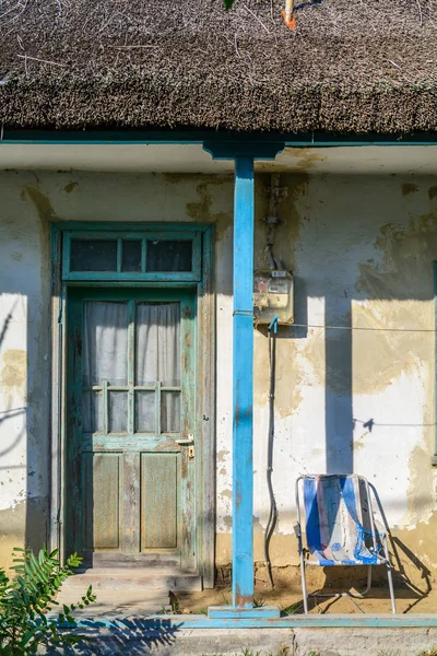 緑のドアと青い柱をヴィンテージの古い壁。フロント側の入り口ドアとの未知のルーマニアの村にある伝統的な藁葺き屋根と、晴れた日に古い家の窓. — ストック写真