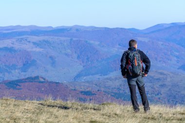 Dağda ayakta genç turist adam. Mutlu genç turist adam